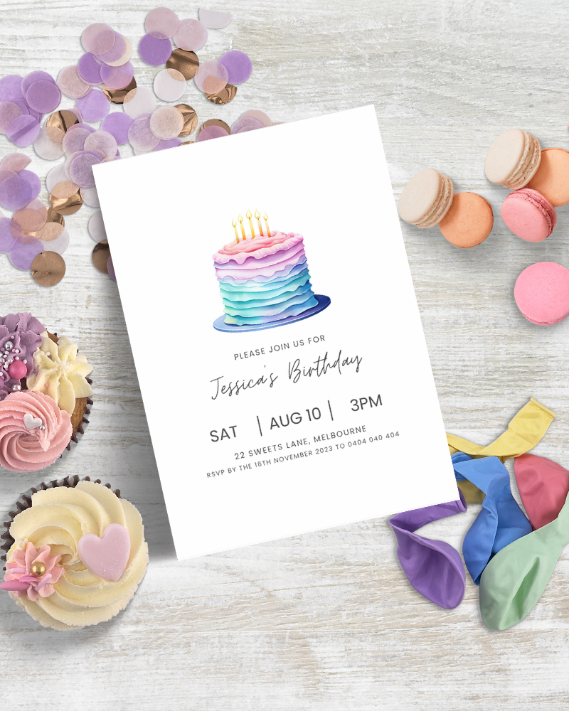 Colorful birthday invitation featuring a layered cake, surrounded by sweets and vibrant balloons on a wooden surface.