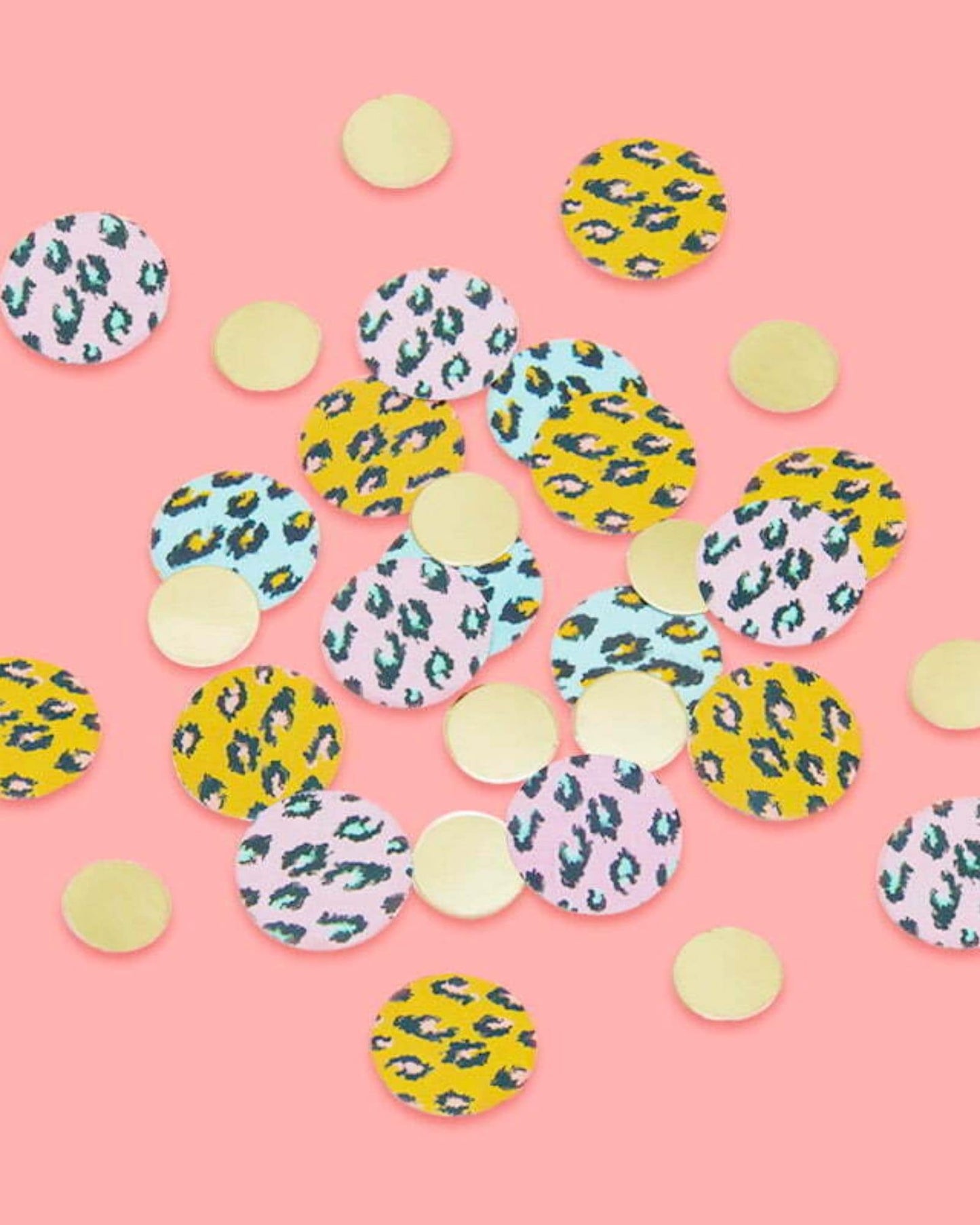 Colorful circular shapes with animal patterns and gold accents scattered on a pink background.