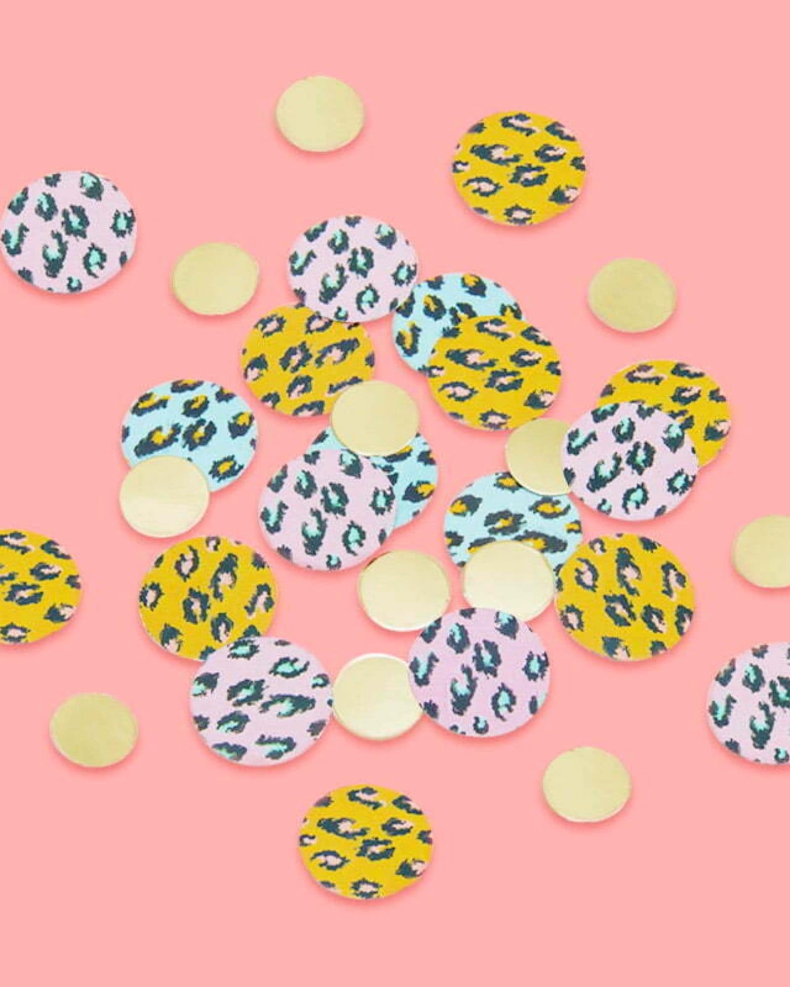 Colorful circular shapes with animal patterns and gold accents scattered on a pink background.