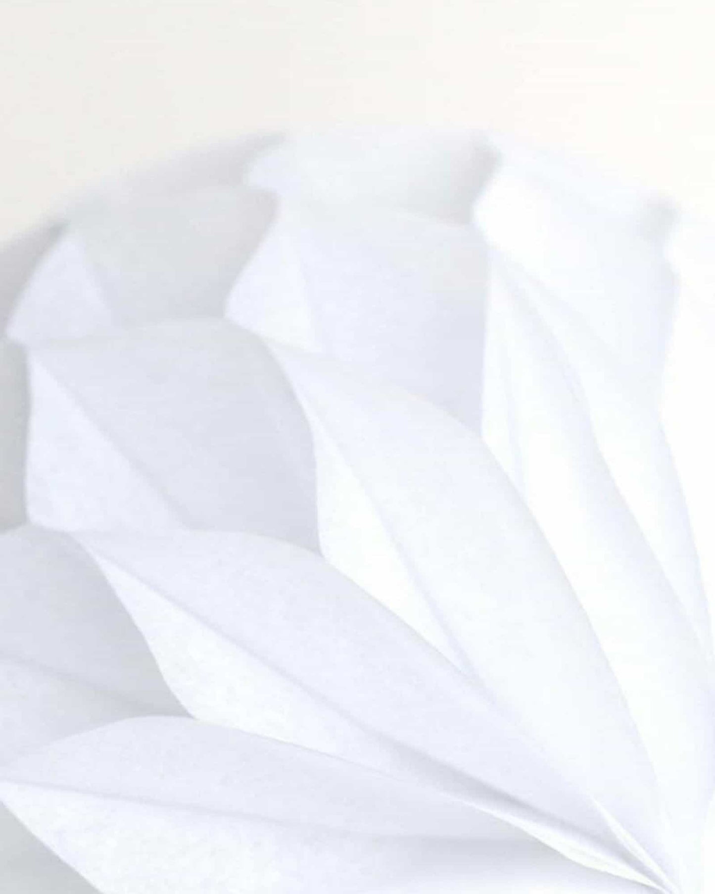 Delicate white layers create a soft, flowing texture against a light backdrop, evoking a sense of tranquility and elegance.