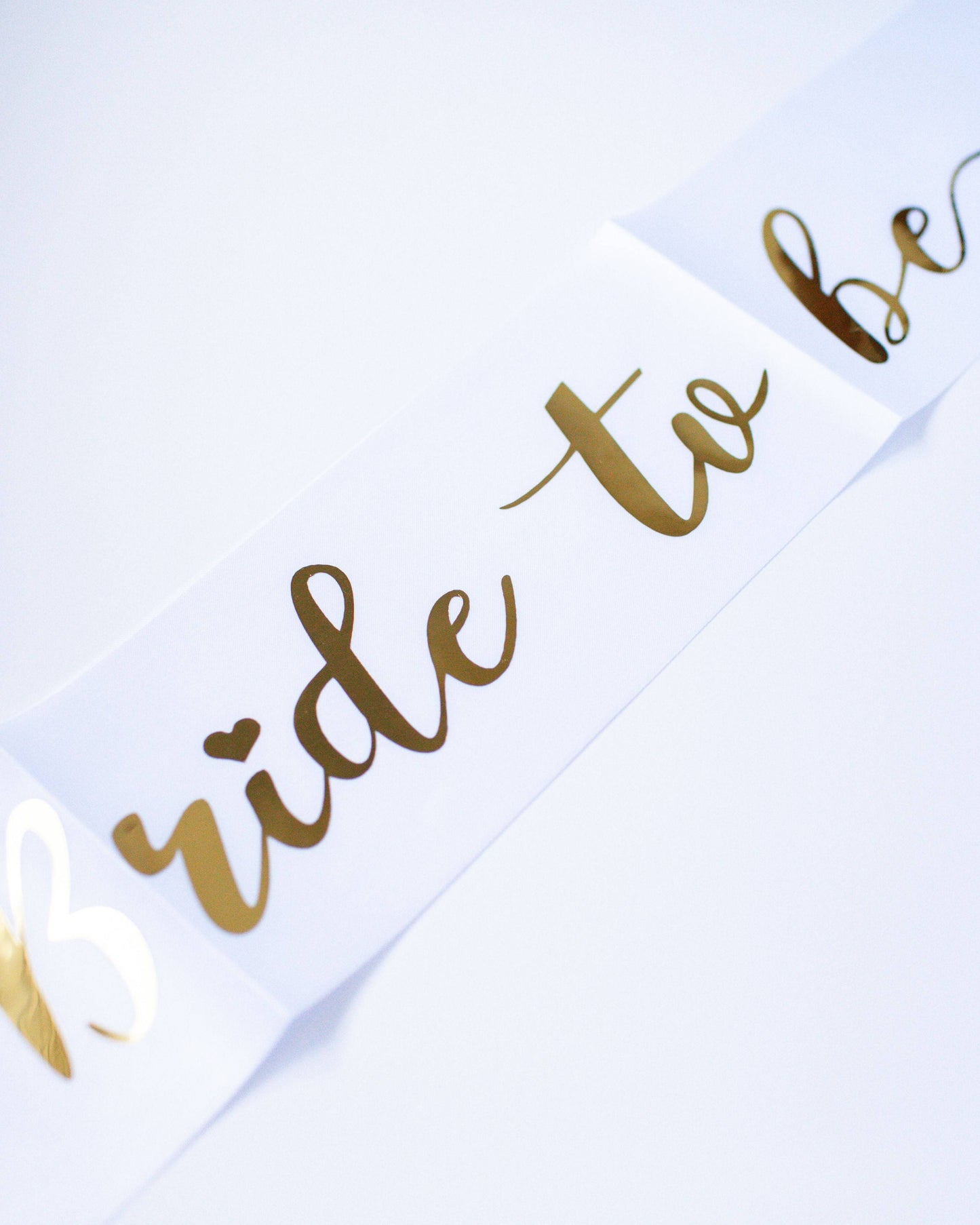 A stylish sash featuring elegant gold lettering that reads "Bride to be" on a clean white background.
