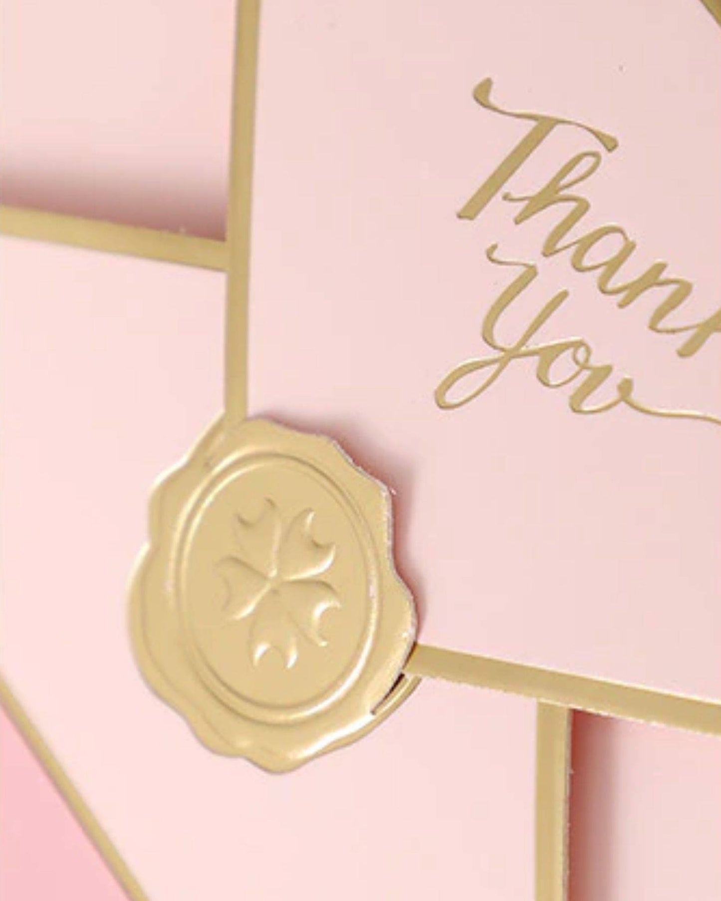 Elegant pink box featuring a golden "Thank You" message and a decorative seal embellishment.