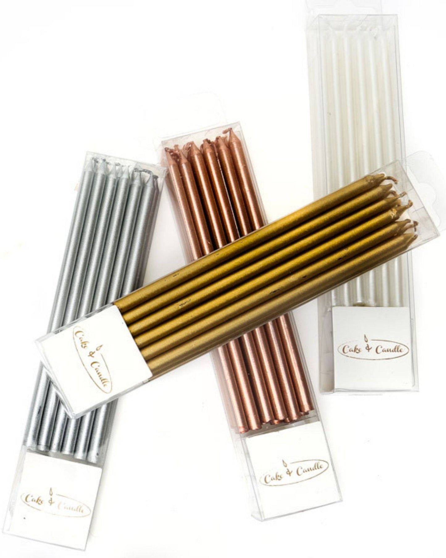 A collection of elegant tall candles in gold, silver, rose gold, and white, neatly packaged for celebrations.
