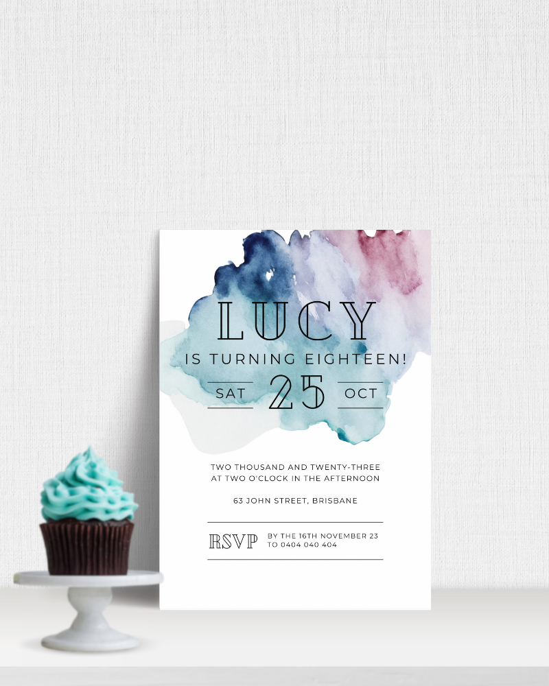 A cupcake with teal frosting beside a colorful invitation for Lucy's 18th birthday celebration.