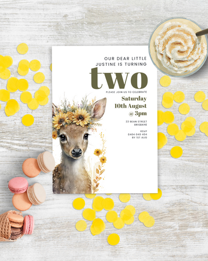 A whimsical invitation featuring a fawn adorned with flowers, surrounded by colorful confetti and treats.