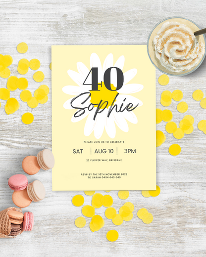 A cheerful birthday invitation featuring yellow petals, colorful macarons, and confetti on a rustic wooden surface.