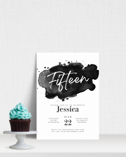 A cupcake with teal frosting beside a stylish invitation for a 15th birthday celebration.