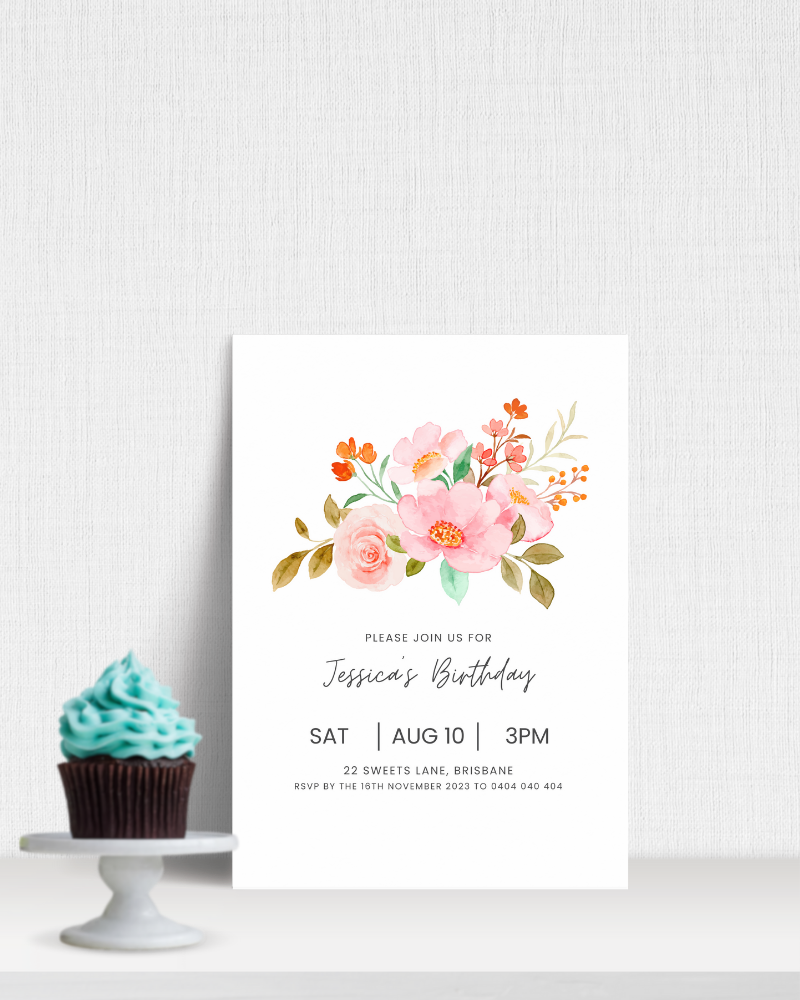 A cupcake with teal frosting beside an invitation featuring floral illustrations and birthday details.