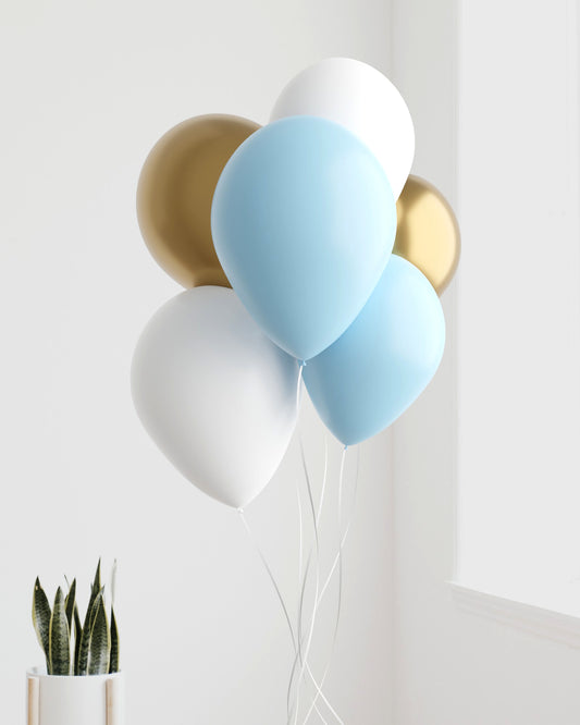 A cluster of blue, white, and gold balloons against a light wall, with a potted plant in the foreground.