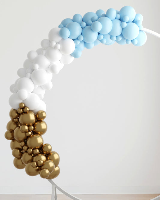 A vibrant arch of blue, white, and gold balloons, creating a festive and cheerful atmosphere against a neutral background.