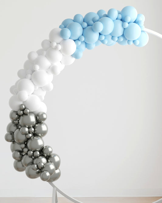 A colorful arch made of blue, white, and silver balloons arranged in a playful, whimsical pattern.