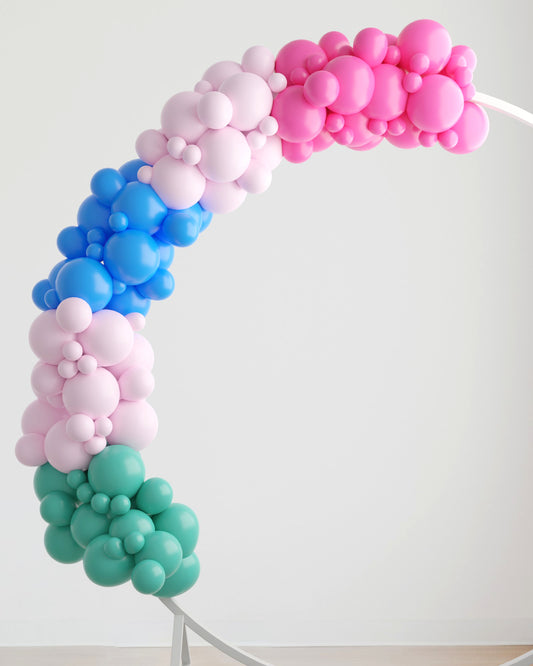 A vibrant arch made of balloons in pink, blue, and green hues, creating a playful and festive atmosphere.