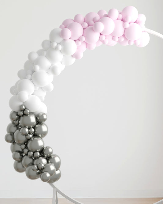 A curved garland made of pink, white, and silver balloons against a minimalistic background.