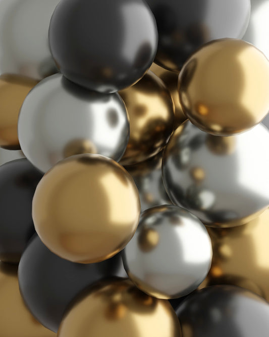 A cluster of shiny black, silver, and gold spheres, creating a festive and elegant visual arrangement.