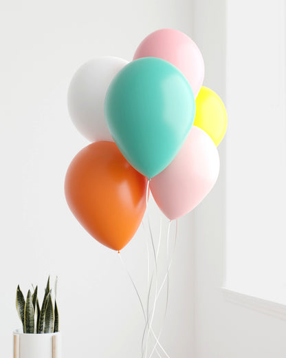 A cheerful bunch of colorful balloons in pastel shades, gently swaying against a light, airy background.