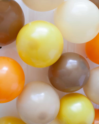 A vibrant cluster of round, glossy spheres in shades of yellow, orange, and brown, creating a cheerful composition.