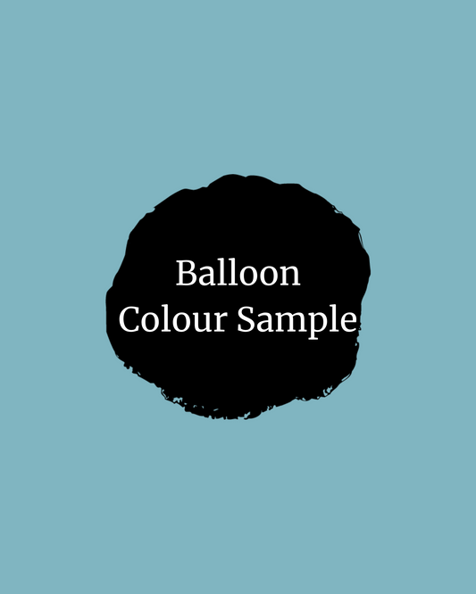 Black circular shape with white text "Balloon Colour Sample" on a soft blue background.