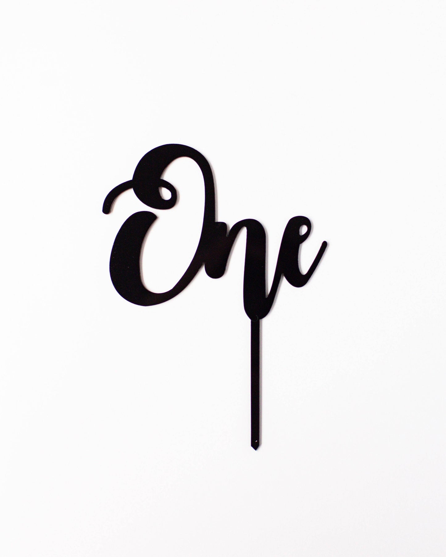 Black acrylic topper featuring the word "One" in a stylish, cursive font against a white background.