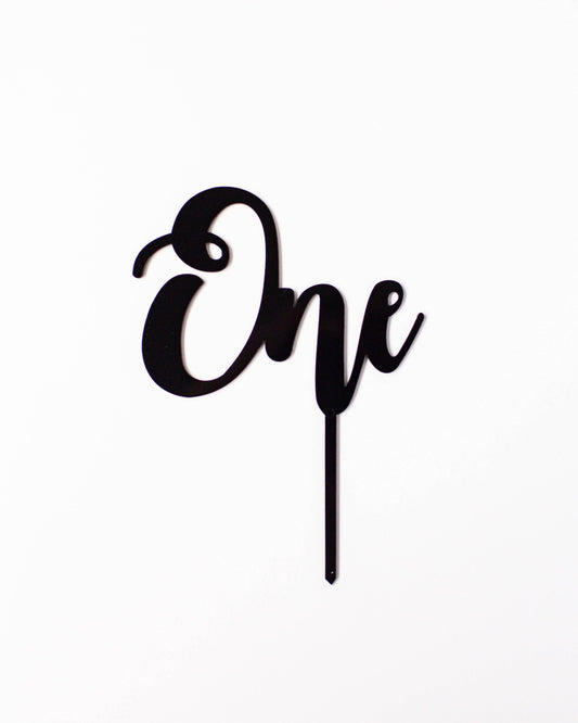 Black acrylic topper featuring the word "One" in a stylish, cursive font against a white background.