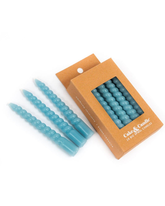 A set of blue spiral candles arranged next to a kraft box, featuring a modern and playful aesthetic.