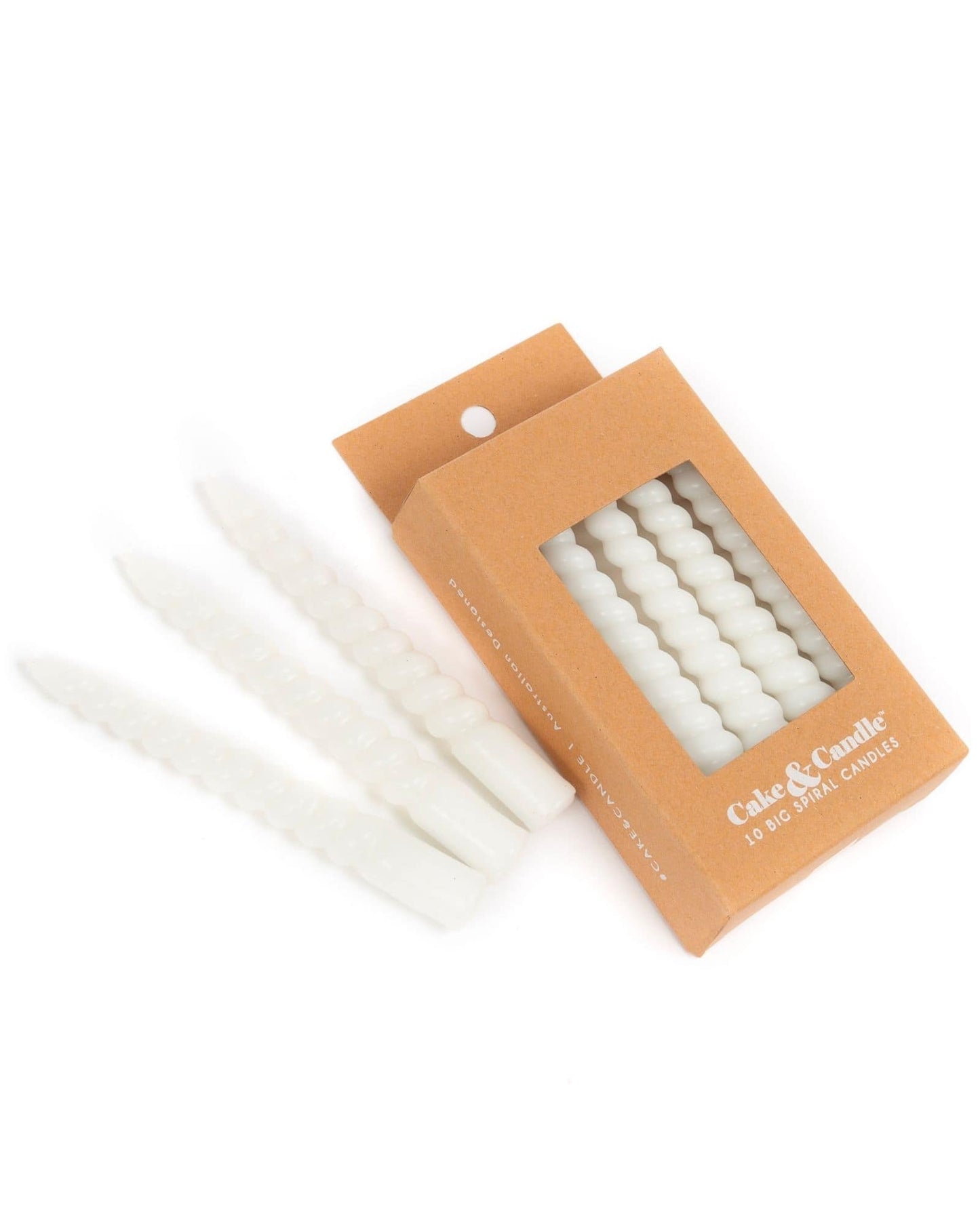 Set of four twisted white candles next to a brown box showcasing ten additional candles inside.