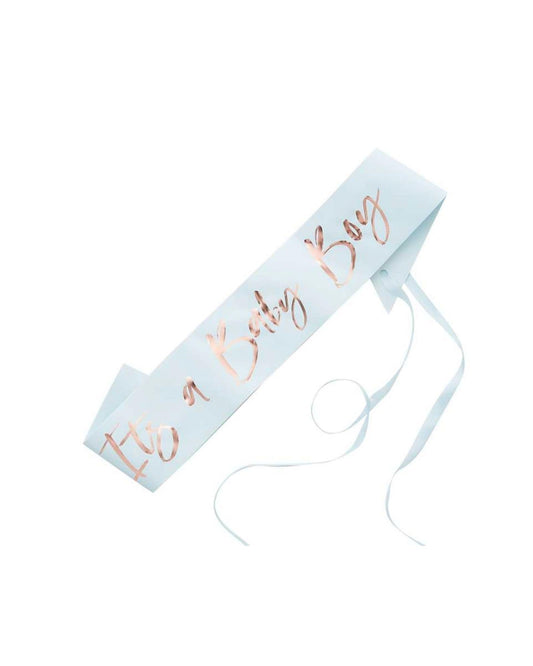 A light blue ribbon featuring "It's a Baby Boy" in elegant rose gold script, tied with flowing ribbons.