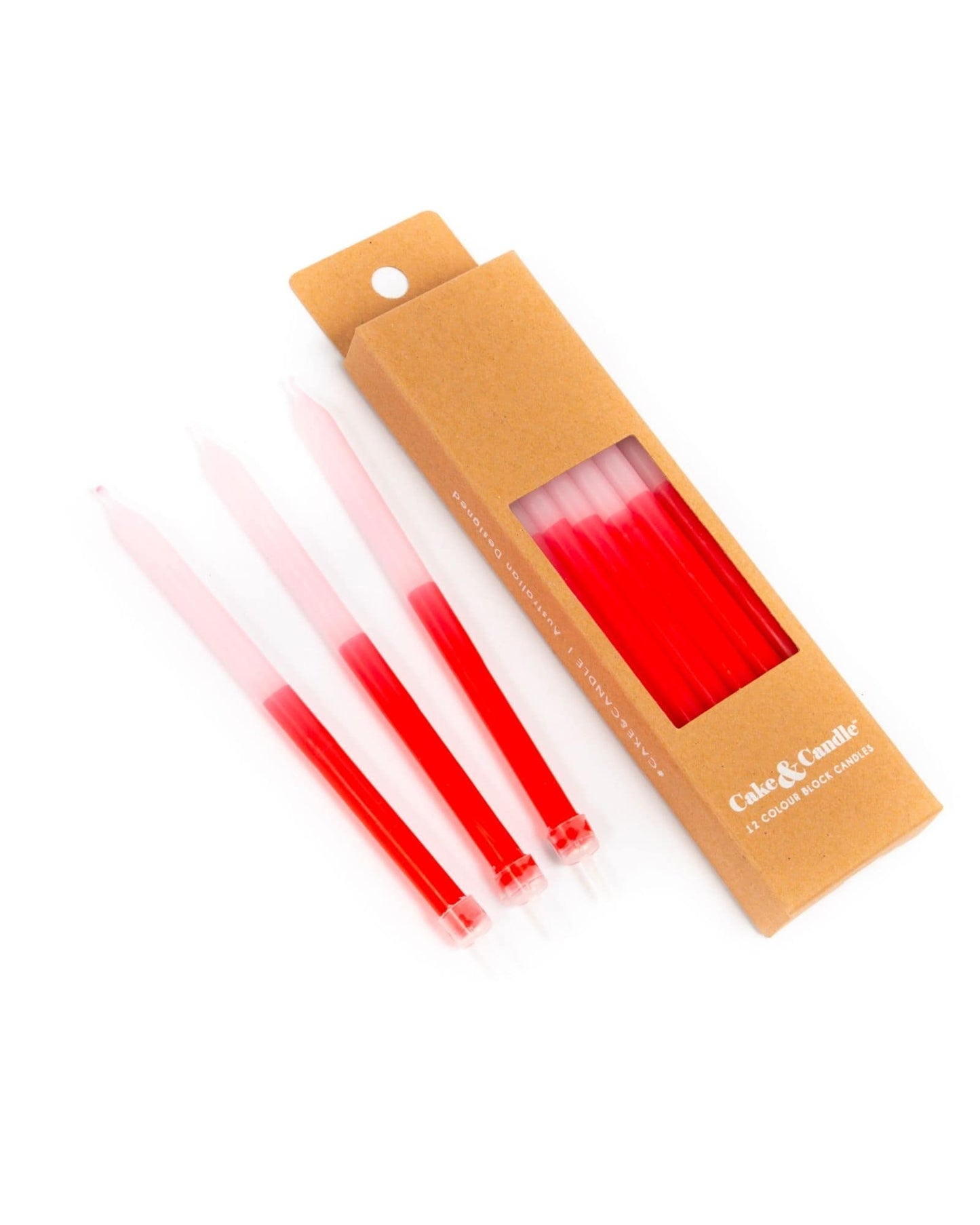 Set of four vibrant red and pink candles packaged in a simple kraft box with a clear window.