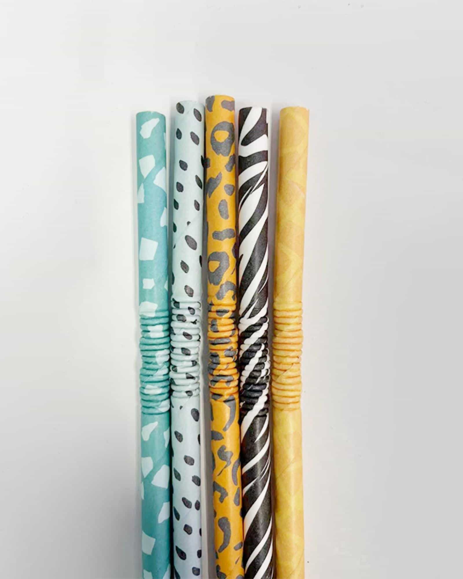 Colorful rolled sheets featuring various patterns, including spots and stripes, arranged in a row on a light background.