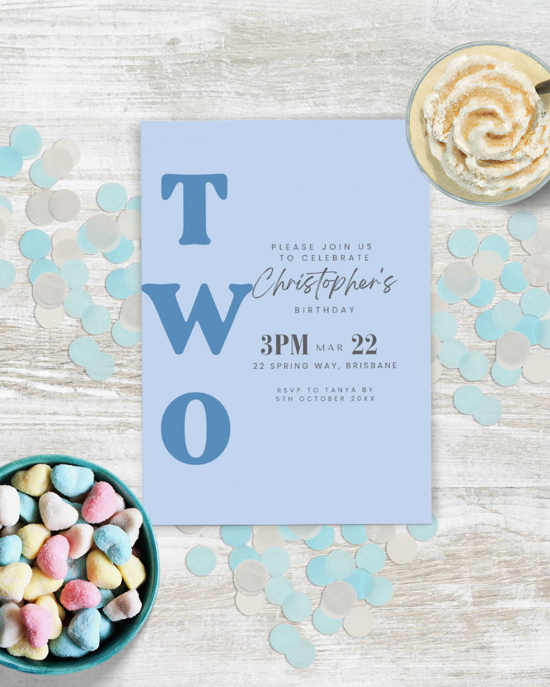 Blue invitation card with large letters, surrounded by colorful confetti and pastel heart-shaped candies.