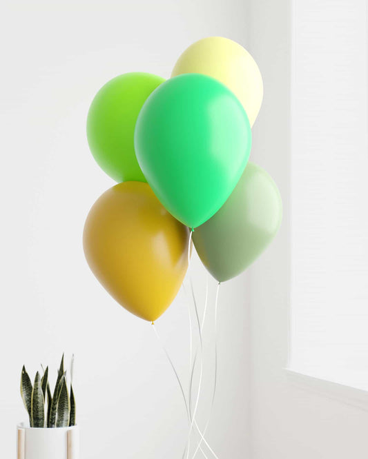 A cluster of vibrant balloons in green, yellow, and brown shades, with a potted plant visible in the background.