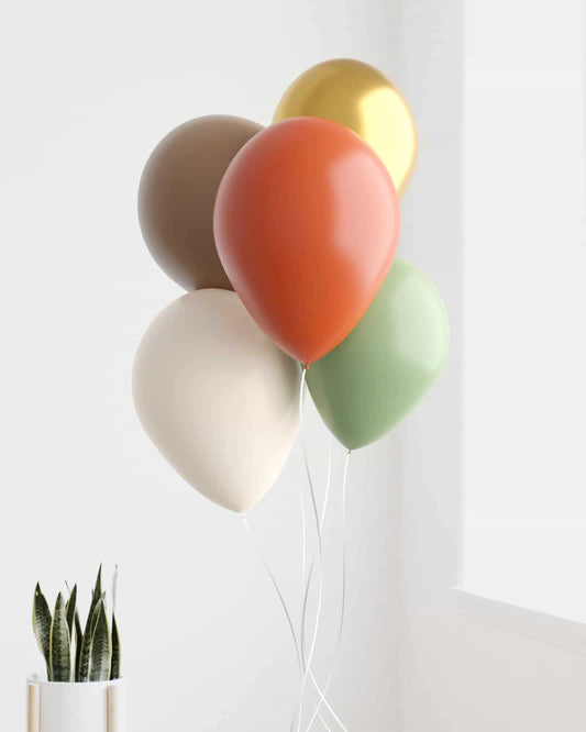 A cluster of colorful balloons in earthy tones, with a potted plant in a white container nearby.