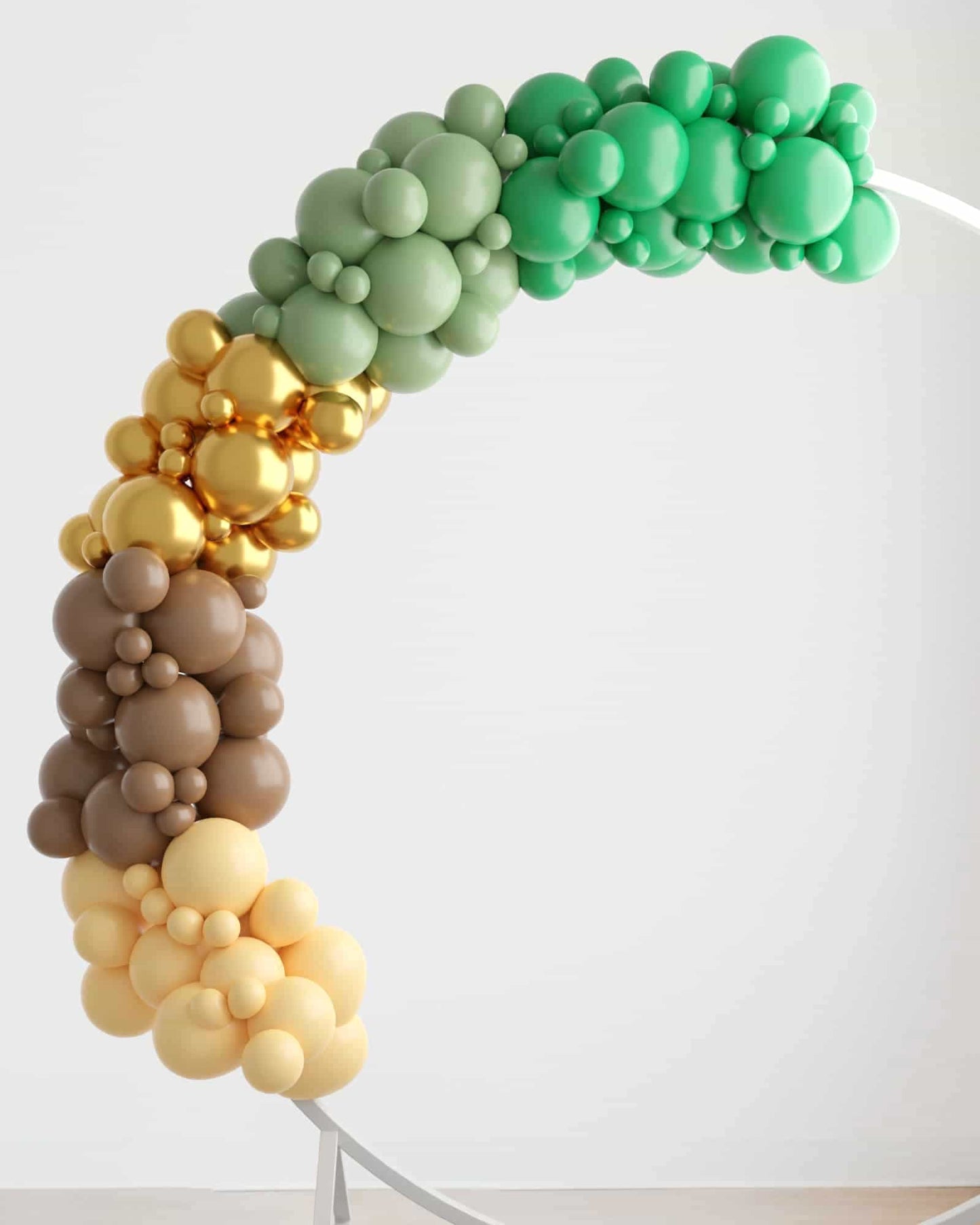 A vibrant balloon garland featuring green, gold, brown, and yellow balloons, gracefully curving against a light backdrop.