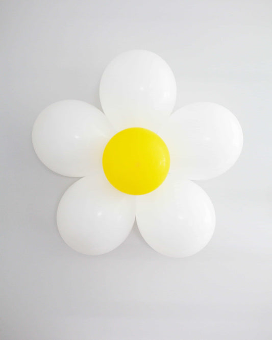 A cheerful daisy made of white and yellow balloons against a light background, adding a whimsical touch to any space.