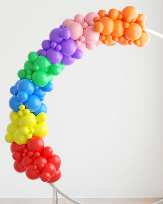 A vibrant arch of colorful balloons in a gradient from red to purple, set against a light background.