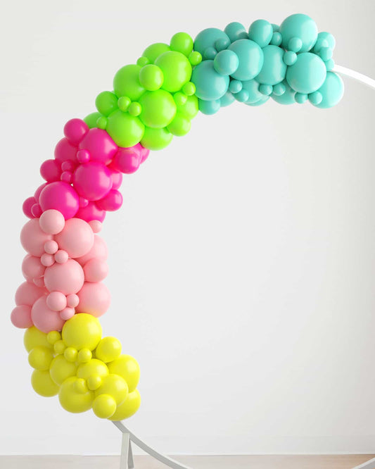 A vibrant balloon garland featuring shades of pink, green, blue, and yellow, elegantly arching against a light backdrop.