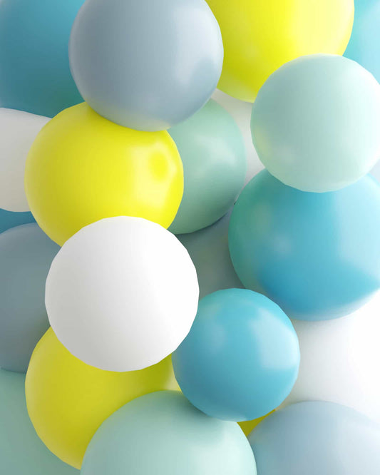 A vibrant mix of glossy spheres in yellow, blue, and white, arranged playfully against a light background.