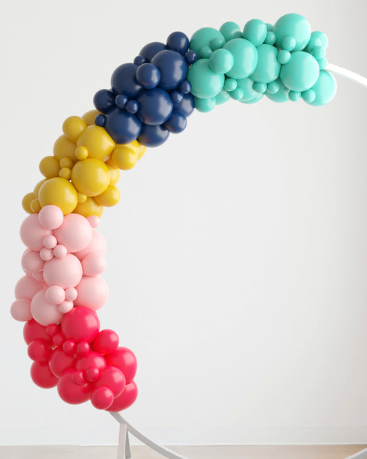 Colorful balloon garland in shades of blue, yellow, pink, and red, arching gracefully against a light background.