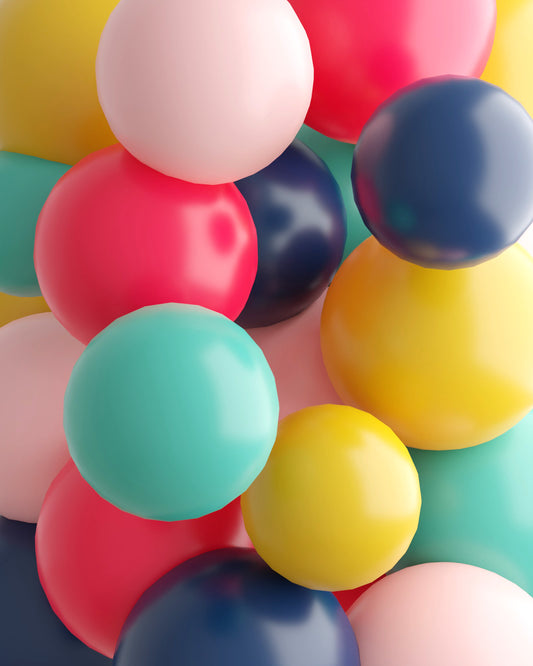 A vibrant cluster of glossy spheres in various colors, including pink, red, yellow, and teal, creating a playful composition.