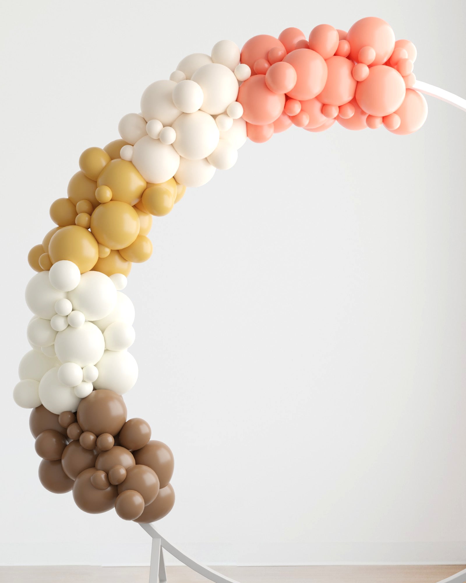 A colorful arch made of various-sized balloons in shades of peach, cream, gold, and brown against a neutral background.