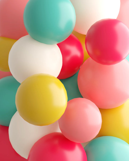 Colorful assortment of glossy spheres in pink, red, yellow, white, and turquoise, creating a playful, vibrant composition.