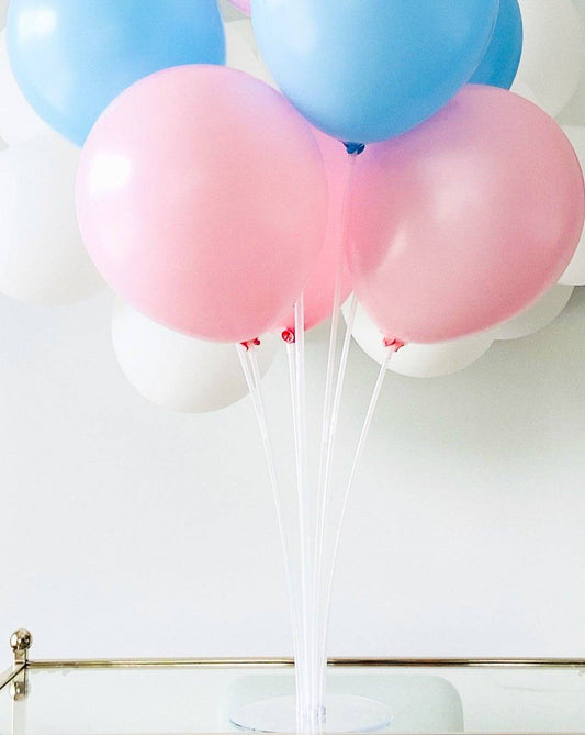 A cluster of blue, pink, and white balloons arranged on clear stands against a light background.