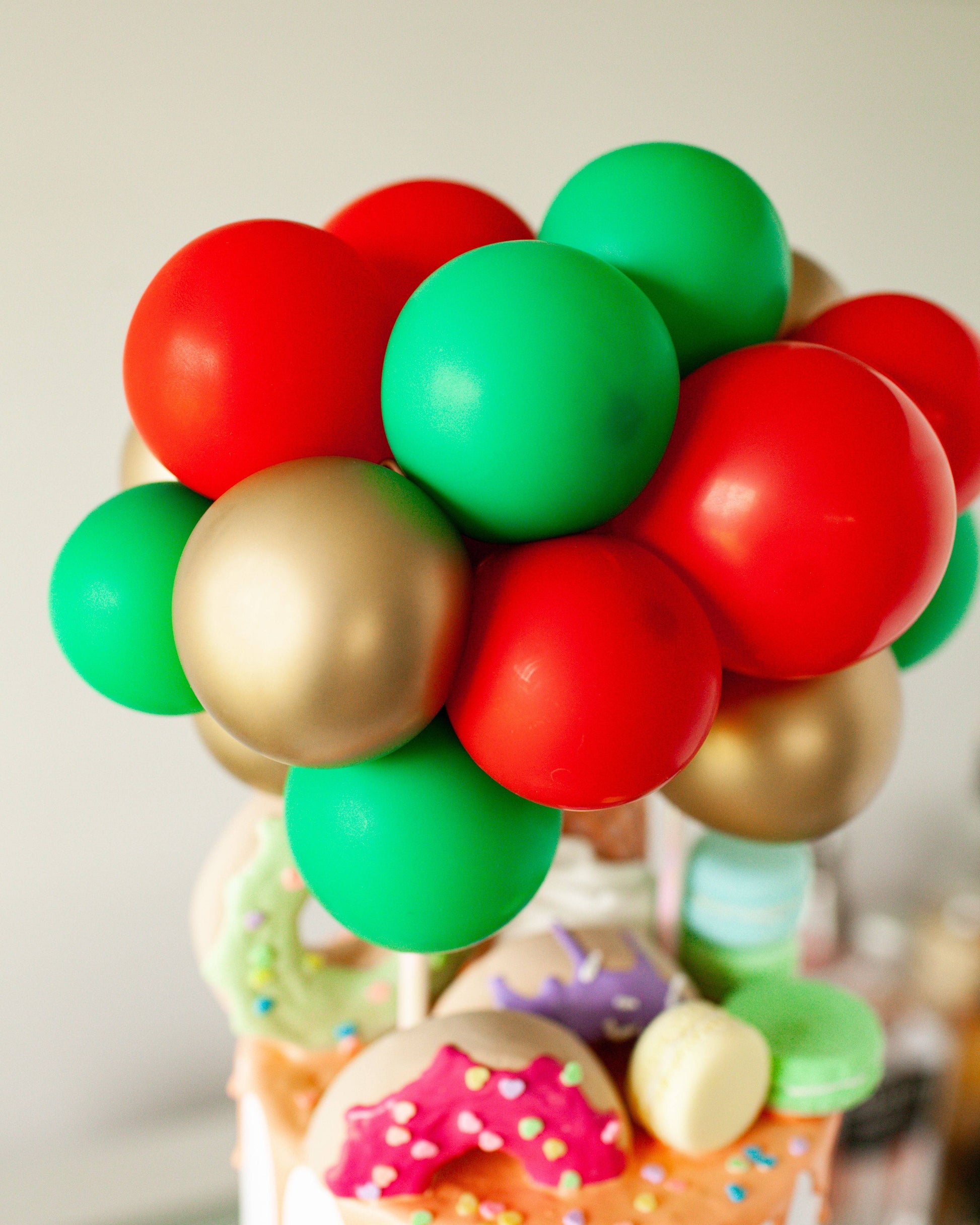 Colorful spheres in red, green, and gold arranged as a festive topper, set against a blurred background.