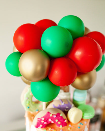 Colorful spheres in red, green, and gold arranged as a festive topper, set against a blurred background.