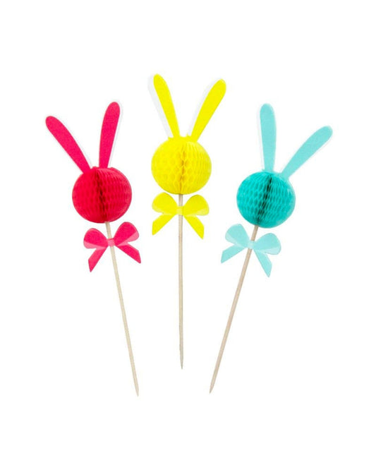 Colorful bunny picks in pink, yellow, and turquoise with honeycomb balls and ribbon bows on wooden sticks.