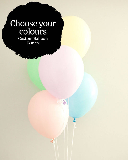 A cluster of pastel balloons in pink, green, blue, and yellow against a soft background, inviting color choices.