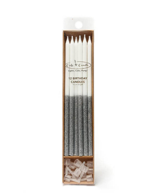 A set of tall white candles with glittery silver tips, packaged with clear holders for celebratory occasions.