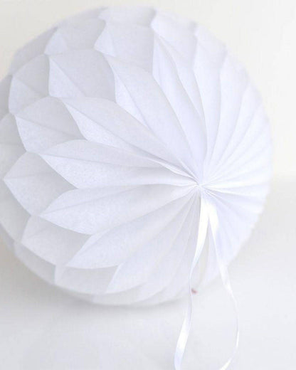 White honeycomb ball with layered, petal-like folds and a delicate ribbon, creating an elegant, airy decor accent.