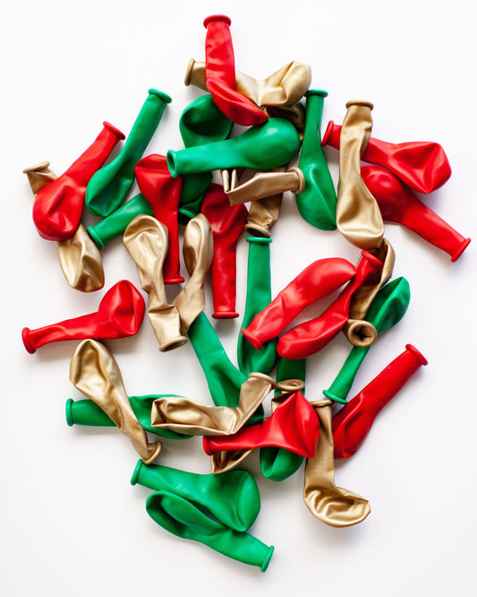 A colorful assortment of red, green, and gold balloons arranged on a white background, evoking festive cheer.