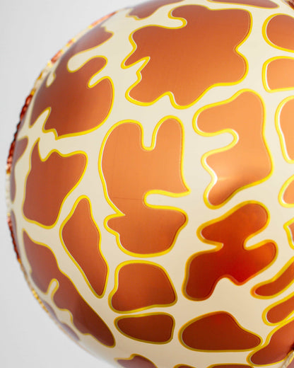 A close-up of a round object featuring a playful, orange and cream pattern resembling a giraffe's spots.