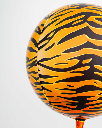 A vibrant orange sphere with a black tiger stripe pattern, suspended against a light background.